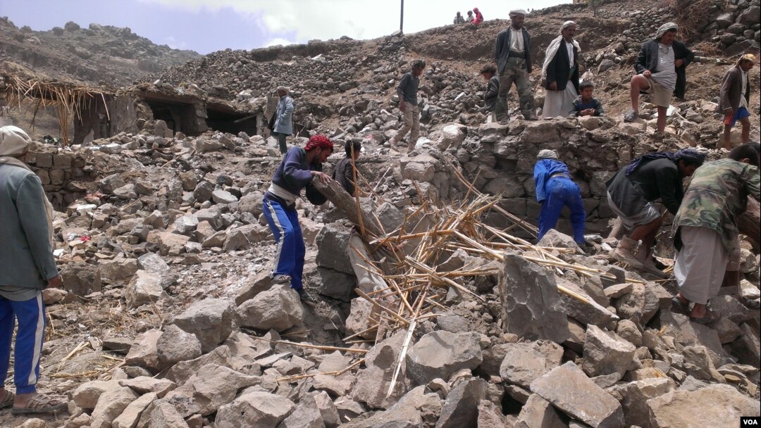 FILE - Locals help villagers that lost their homes recover their belongs that were scattered during the bombing of Hajar Aukaish, Yemen. (A. Mojalli/VOA)