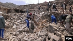 Locals help villagers that lost their homes recover their belongs that were scattered during the bombing of Hajar Aukaish, Yemen, April 2015. (A. Mojalli/VOA)
