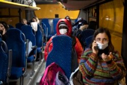 A migrant from Guinea headed to France sits on a bus to the Italian border town of Cesana to start a border crossing attempt though the French-Italian alps, Saturday, Dec. 11, 2021.