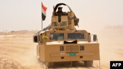Iraqi government forces drive their armored vehicle, June 22, 2016, some 40 kilometers (25 miles) west of Qayyarah, during their operation to take the city and make it a launchpad for Mosul. 