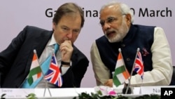 British Minister of State for Foreign and Commonwealth Office Hugo Swire, left, interacts with India’s Gujarat state chief minister Narendra Modi at Gandhinagar in Gujarat, India, Wednesday, March 20, 2013. Swire was accompanied by a large business delegation including a team from UK's oil and gas major BG Group. According to local news reports, the BG Group, Wednesday signed an agreement for the supply up to 2.5 million tonnes per annum of liquefied natural gas (LNG) to the state-owned Gujarat State Petroleum Corporation Ltd. (AP Photo/Ajit Solanki)