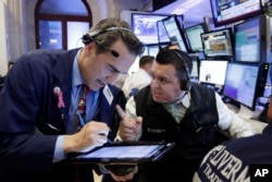 Traders Gregory Rowe, left, and Robert Finnerty work on the floor of the New York Stock Exchange, Nov. 9, 2016. Stocks are moving solidly higher in midday trading on Wall Street following Donald Trump's victory speech.