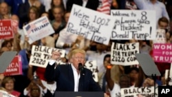 Presiden Donald Trump mengepalkan tangannya memberi semangat kepada para pendukungnya di akhir rapat akbar (18/2). Melbourne, Florida. (foto: AP Photo/Chris O'Meara)