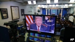 Predsednik Donald Tramp vidi se na ekranima u sobi za brifinge Bele kuće, dok se u udarnom terminu obraća naciji iz Ovalnog kabineta, 8. januara 2019.