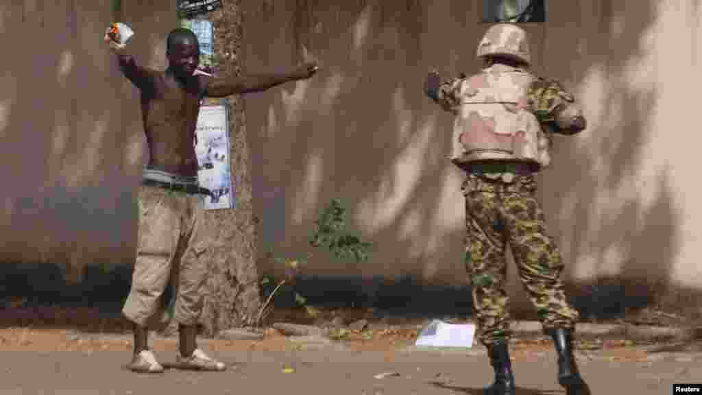 An anti-government protester faces down a soldier outside the parliament building in Ouagadougou, capital of Burkina Faso, Oct. 30, 2014. 