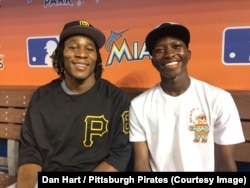 Gift Ngoepe with his brother, Victor, sit in the visitors dugout of the Miami Marlins ballpark in Florida. Victor Ngoepe, 19, also has a contract with the Pittsburgh Pirates and is playing on a minor league team in Florida.