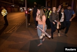 Concert goers react after fleeing the Manchester Arena in northern England where U.S. singer Ariana Grande had been performing in Manchester, Britain, May 22, 2017.