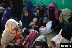 FILE - Rohingya refugee women wait outside of a medical center at Jamtoli camp in Cox's Bazar, Bangladesh, Jan. 22, 2018.