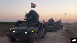 This image made from a video shows Iraqi soldiers on military vehicles in the Qatash area moving towards Kirkuk gas plant, Oct. 16, 2017.