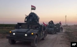 This image made from a video shows Iraqi soldiers on military vehicles in the Qatash area moving towards Kirkuk gas plant, Oct. 16, 2017.