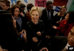 FILE - Democratic presidential candidate Hillary Clinton, center, greets supporters as she visits her campaign field office in Oakland, Calif., May 6, 2016.
