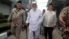 Abu Bakar Ba'asyir (tengah), tersangka dalang Bom Bali 2002 berjalan bersama Yusril Ihza Mahendra (kanan), penasihat pasangan capres-cawapres Joko Widodo-Ma'ruf Amin, di Lapas Gunung Sindur di Bogor, Indonesia, 18 Januari 2019.