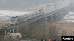 Sebuah kereta menuju Seoul dari stasiun kereta api Dorasan, stasiun Korsel terdekat Korut, melintasi jembatan kereta api Imjingang dekat zona demiliterisasi yang memisahkan dua Korea di Paju, 52 km (32 mil) di utara Seoul dan 209 km (130 mil) selatan Pyongyang, 18 Januari 2009. 