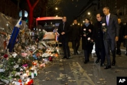 FILE - President Barack Obama, right, French President Francois Hollande, second from right, and Paris Mayor Anne Hidalgo arrive at the Bataclan, site of one of the Paris terrorists attacks, to pay their respects to the victims, Nov. 30, 2015.