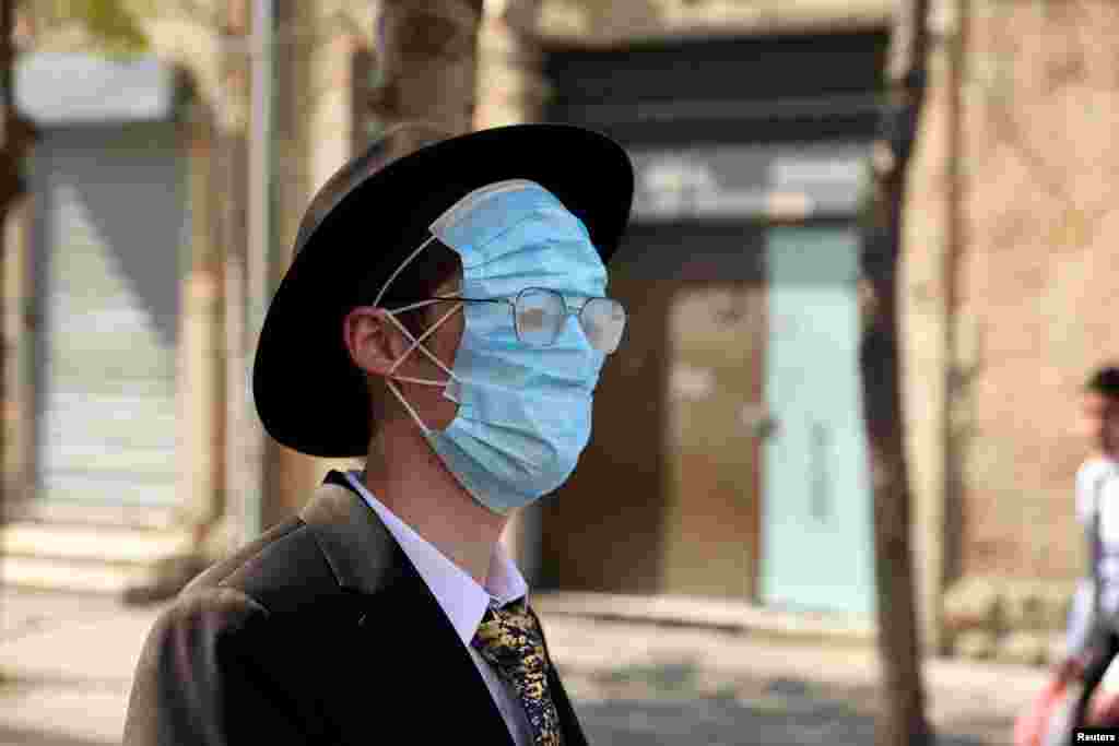 An Ultra Orthodox man wears three masks on his face while celebrating Purim amid coronavirus disease (COVID-19) restrictions in Jerusalem.