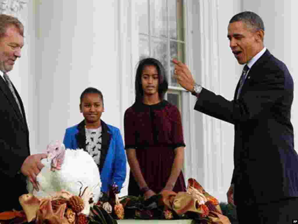 President Barack Obama, with daughters Sasha and Malia, pardons a turkey named Liberty a day before Thanksgiving. (AP)