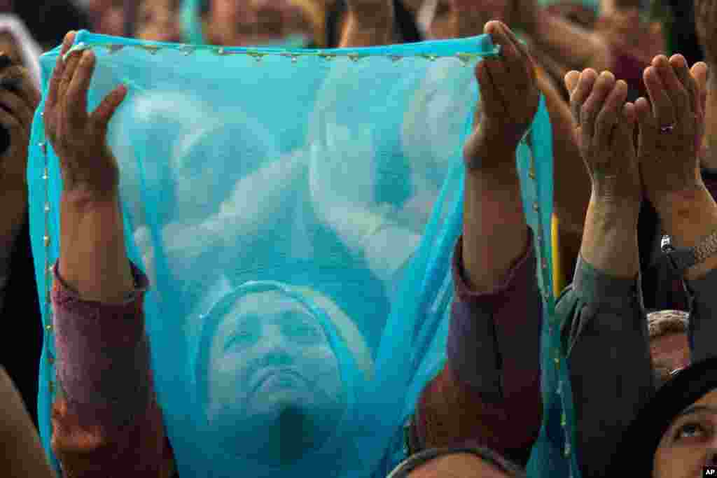 Kashmiri Muslim women pray as a head priest, unseen, displays a holy relic believed to be the hair from the beard of Prophet Mohammed, on the occasion of Mehraj-u-Alam, at the Hazratbal Shrine on the outskirts of Srinagar, India.