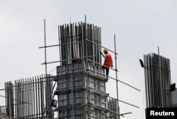 works at a construction site of an apartment complex in Colombo March 8, 2016. Sri Lankan Prime Minister Ranil Wickremesinghe, saying his country must break out of a debt trap, on Tuesday announced a rise in value added tax (VAT) and said the government will impose a capital gains tax.