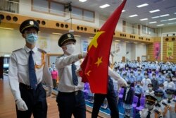 Siswa mengenakan masker untuk membantu mencegah penyebaran virus COVID-19, menghadiri upacara pengibaran bendera nasional China pada hari pertama tahun ajaran baru di sekolah menengah, di Hong Kong, Rabu, 1 September 2021.