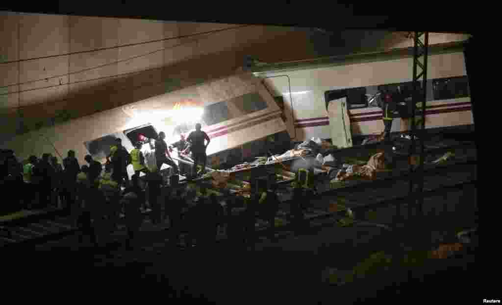 24일 스페인 북서부 산티아고 데 콤포스텔라시 고속열차 탈선 사고 현장에서, 구조대가 생존자들을 열차 밖으로 구출해내고 있다.