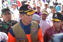 Kepala BNPB Letjen TNI Doni Monardo berbicara dengan warga yang baru terkena bencana (Foto: BNPB).