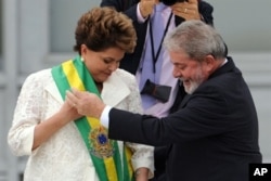 FILE - Newly sworn-in Brazilian President Dilma Rousseff receives the presidential sash from outgoing President Luiz Inacio Lula da Silva at the Planalto Palace in Brasilia, Jan. 1, 2011.