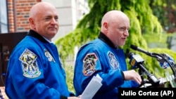 FILE - Former astronaut Scott Kelly, right, speaks while standing next to his astronaut twin brother Mark Kelly during an event renaming the elementary school on May 19, 2016, in West Orange, N.J. (AP Photo/Julio Cortez)