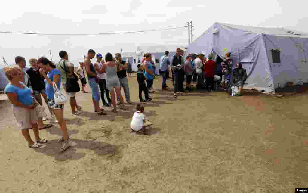 New arrivals stand in a line to register at a refugee camp in Russia&#39;s Rostov region, Aug. 18, 2014.