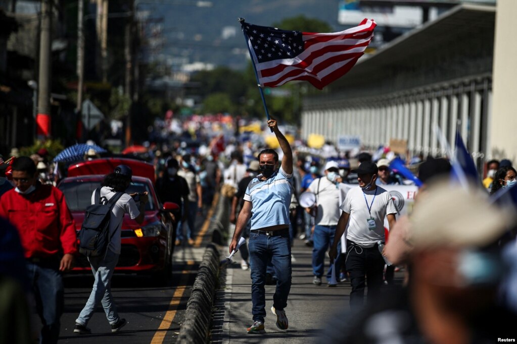 Un hombre agita una bandera estadounidense durante una protesta contra las acciones del Gobierno del presidente de El Salvador, Nayib Bukele.