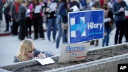Kara Bonham, at left, registers to vote for the Democratic caucus at the University of Nevada, Feb. 20, 2016, in Reno, Nev.