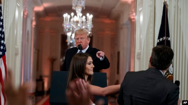 特朗普总统与CNN记者阿科斯塔在记者会上言辞交锋，一名白宫实习生试图从阿科斯塔手中拿走麦克风。(2018年11月7日)