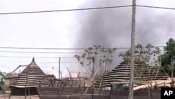 Burning huts in Abyei after northern Sudan forces seized the disputed oil-rich region.