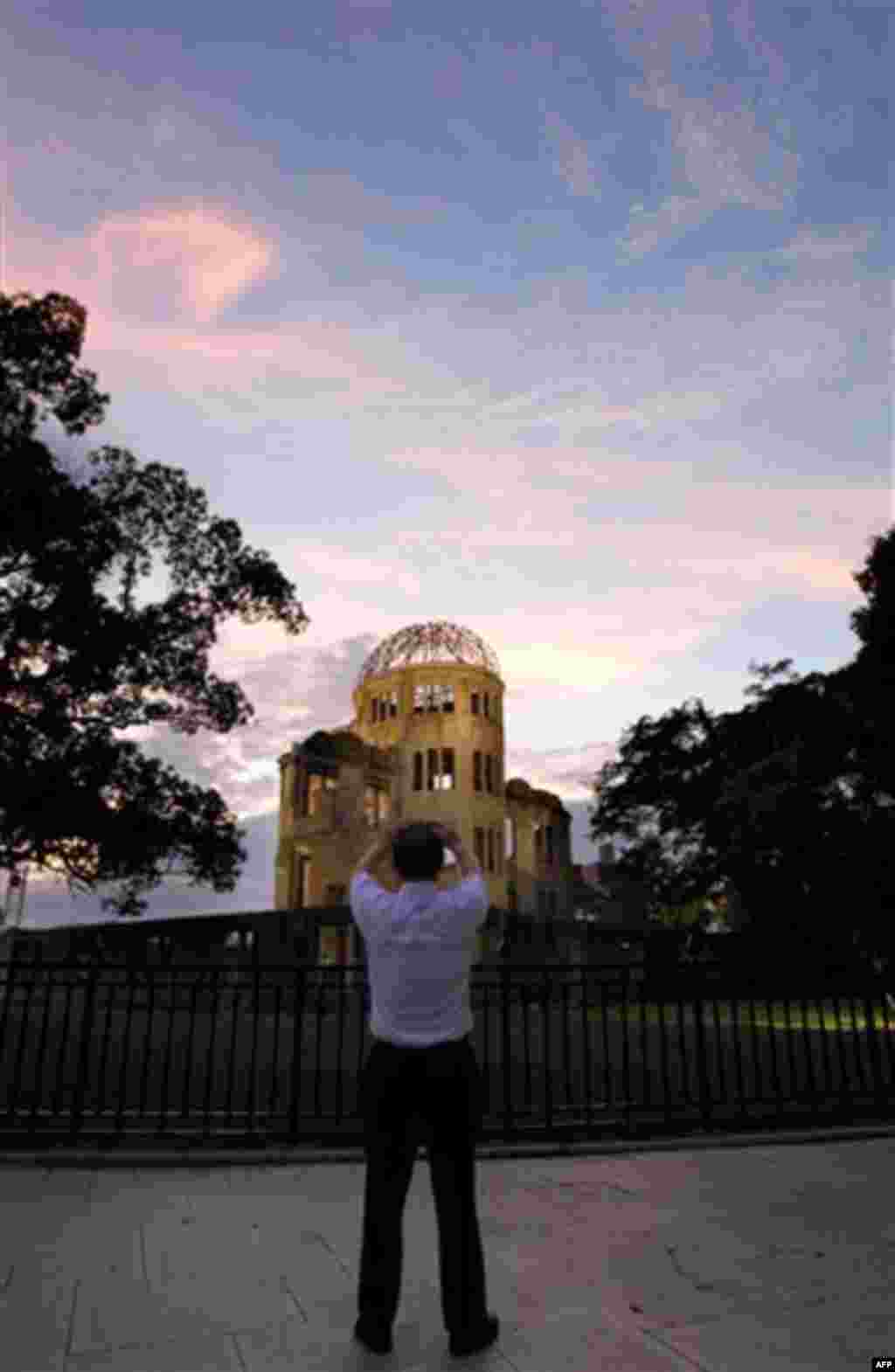 A man takes pictures of the Atomic Bomb Dome at sunset in Hiroshima, western Japan, Friday, Aug. 5, 2011 on the eve of the 66th anniversary of the world's first atomic bombing on the city. (AP Photo/Koji Sasahara)