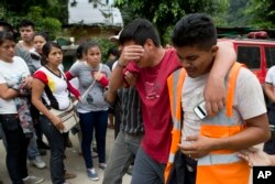 Residents cry after finding out one of their family members died in the mudslide in Cambray, a neighborhood in the suburb of Santa Catarina Pinula, on the outskirts of Guatemala City, Oct. 3, 2015.