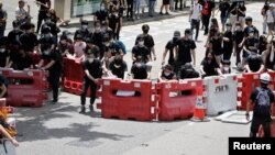 Para pengunjuk rasa memasang penghalang untuk memblokir satu dari jalan utama di Hong Kong, 21 Juni 2019.