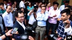 Kay Kimsong, left wearing glasses, editor-in-chief of the Phnom Penh Post, speaks to reporters after being fired by the newspaper's new owner for a report it published Monday about the publication's sale and its new owner, in Phnom Penh, Cambodia, Monday, May 7, 2018. The newspaper's sale was announced Sunday by its former publisher, Australian businessman Bill Clough, with the buyer being a little-known Malaysian public relations executive, Sivakumar Ganapathy who has links to the Cambodian government. (AP Photo)