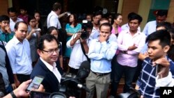 Kay Kimsong, left wearing glasses, editor-in-chief of the Phnom Penh Post, speaks to reporters after being fired by the newspaper's new owner for a report it published Monday about the publication's sale and its new owner, in Phnom Penh, Cambodia, Monday, May 7, 2018. The newspaper's sale was announced Sunday by its former publisher, Australian businessman Bill Clough, with the buyer being a little-known Malaysian public relations executive, Sivakumar Ganapathy who has links to the Cambodian government. (AP Photo)