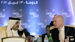Britain's Foreign Secretary William Hague (r) talks with Qatar's Crown Prince Sheikh Tamim bin Hamad al-Thani before the start of the first contact group meeting on Libya in Doha, Qatar, April 13, 2011