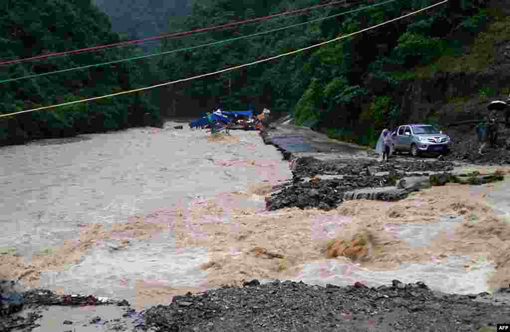 Floodwaters damage a road in Jianhe county in Qiandongnan, southwest China&#39;s Guizhou province. Heavy rainstorms over the past month have left 31 people dead or missing in southwest China&#39;s Guizhou Province, local authority said.