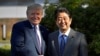 FILE - Then-U.S. President Donald Trump shakes hands with then-Japanese Prime Minister Shinzo Abe upon his arrival at the Kasumigaseki Country Club in Kawagoe, near Tokyo, Nov. 5, 2017.