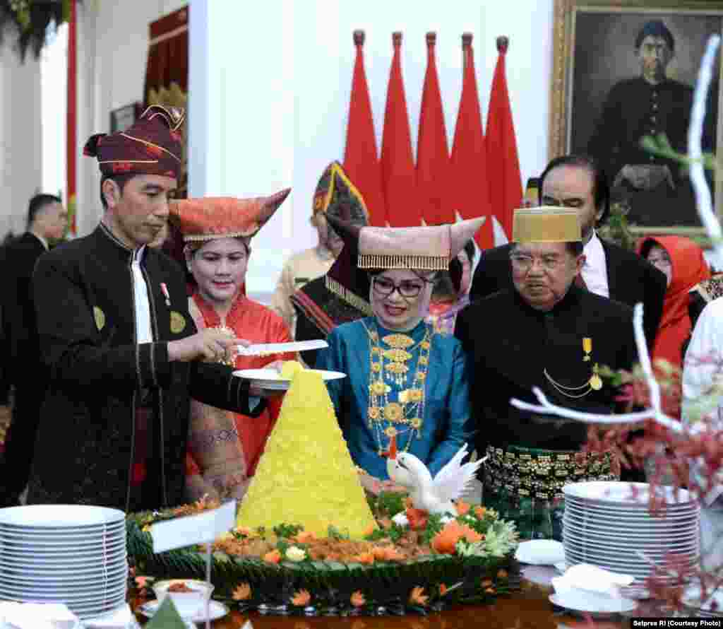 Presiden Joko Widodo didampingi Ibu Negara Iriana, Wakil Presiden Jusuf Kalla dan Ibu Mufidah memotong tumpeng merayakan syukuran Hari Kemerdekaan RI ke 72, Jakarta, 17 Agustus 2017. (Courtesy: Setpres RI)