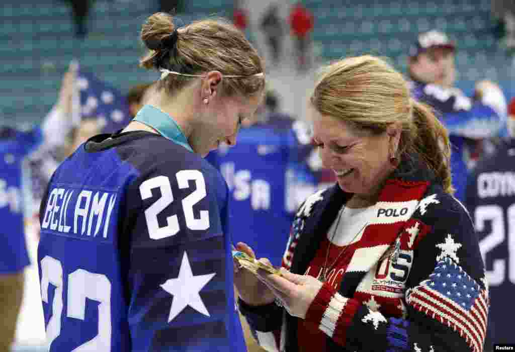 Kacey Bellamy of the U.S. shows her mother, Maura, her gold medal after the U.S. defeated Canada in the women's gold medal hockey game in Gangneung, South Korea, Feb. 22, 2018.