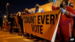 Les gens manifestent en faveur du décompte de tous les votes lors du vote du Nevada devant le département des élections du comté de Clark, mercredi 4 novembre 2020, à Las Vegas.