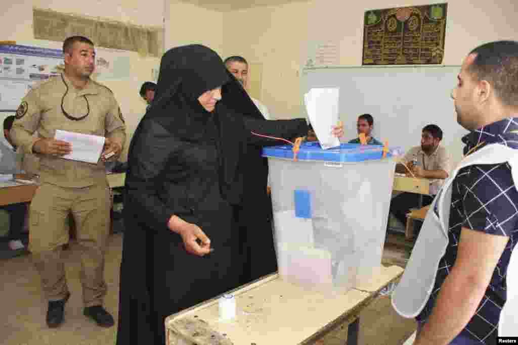 A police officer casts her ballot inside a polling station during early voting for the parliamentary election, in the Sadr City district of Baghdad, April 28, 2014. Iraq will be holding its national elections on April 30. REUTERS/Wissm al-Okili (IRAQ - Ta