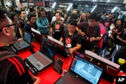 Visitors review new MSI computer products during the Computex Taipei, one of the world's largest IT expos, in Taipei, Taiwan, June 5, 2018.