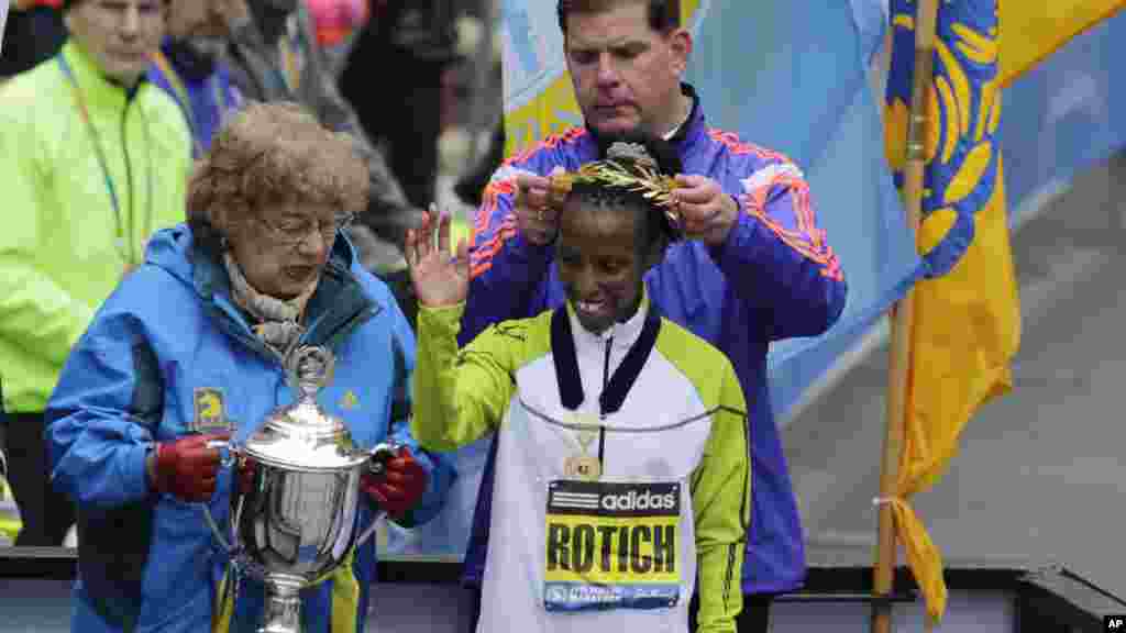 Meya wa Boston Marty Walsh amvaza taji Caroline Rotich, wa Kenya, baada ya kushinda upande wa wanawake mbio za Boston Marathon.