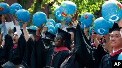 Public policy and government graduate students hold inflatable globes during Harvard University commencement exercises, Thursday, May 24, 2018, in Cambridge, Mass. (AP Photo/Michael Dwyer)