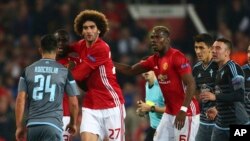 Marouane Fellaini de Manchester United tient le dos de son co-équipier Eric Bailly lors du match retour de demi-finale d’Europa League contre Celta Vigo au stade Old Trafford à Manchester, Angleterre, 11 may 2017.