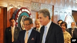 Pakistan's Foreign Minister Shah Mehmood Qureshi, right, walks with his Indian counterpart S.M. Krishna, left, as they arrive for talks in Islamabad, 15 July 2010
