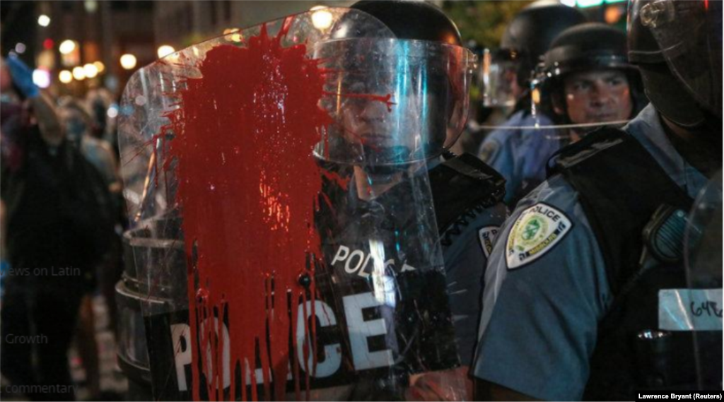 Des policiers sont arrosés de peinture rouge lors des manifestations à St Louis, le 16 septembre 2017.
